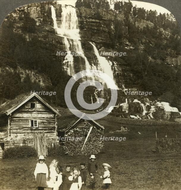 'Children at play in a farmer's field with terraced Tvinde waterfall, Vossevangen, Norway', c1905. Creator: Unknown.