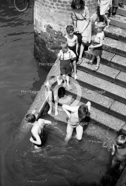 Children bathing in the River Thames, Tower Pier approach, Stepney, London, c1945-c1965. Artist: SW Rawlings