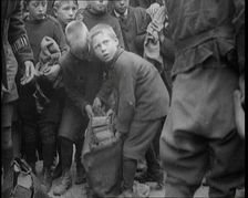 Children Dressed in Scruffy Clothes Gathering Fire Wood Into Sacks, 1920. Creator: British Pathe Ltd