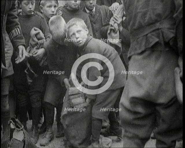 Children Dressed in Scruffy Clothes Gathering Fire Wood Into Sacks, 1920. Creator: British Pathe Ltd.