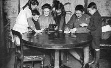 Children emptying their money boxes to invest in war bonds, 1936