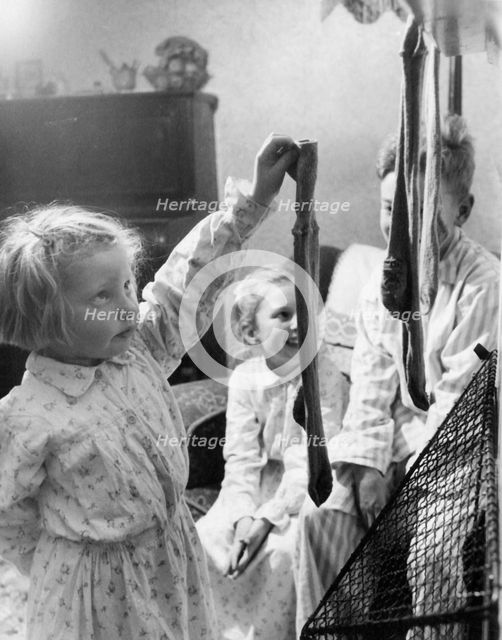Children hanging up Christmas stockings, c1955. Creator: Arthur Charles Kirby Ware.