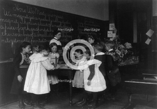 Children in school in Washington, D.C. - learning how a compass is made, (1899?). Creator: Frances Benjamin Johnston.