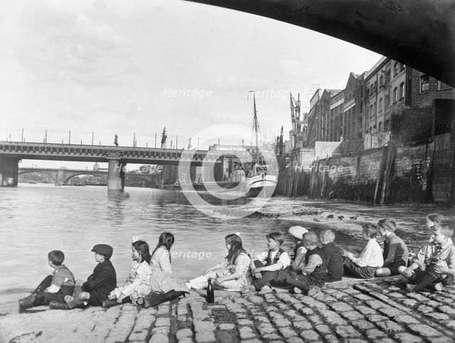 Children on the cobbled causeway under Southwark Bridge, London, c1930. Creator: George Davison Reid.