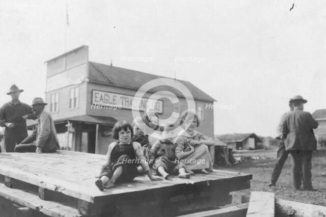 Children outside Eagle Trading Company, between c1900 and 1916. Creator: Unknown.