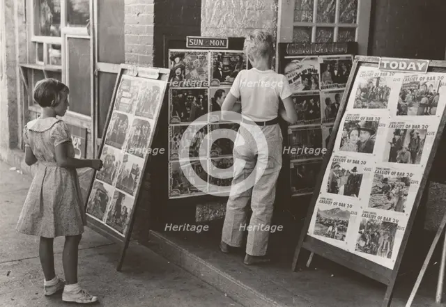 Children looking at posters in front of movie, Saturday, Steele, Missouri,  1938-08. Creator: Russell Lee.