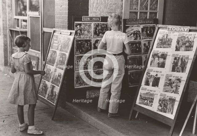 Children looking at posters in front of movie, Saturday, Steele, Missouri,  1938-08. Creator: Russell Lee.