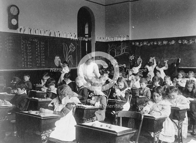 Children modeling clay at desks and drawing on blackboard in Washington, D.C. classroom, (1899?). Creator: Frances Benjamin Johnston.