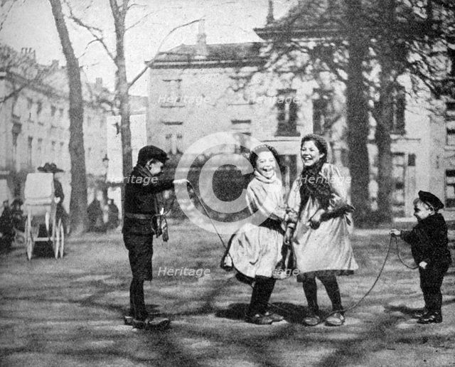 Children skipping in the Grand Place, Bruges, Belgium, 1922.Artist: FC Davis