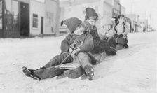 Children sleigh riding, between c1900 and c1930. Creator: Unknown