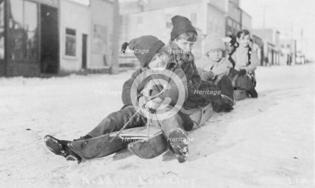 Children sleigh riding, between c1900 and c1930. Creator: Unknown.