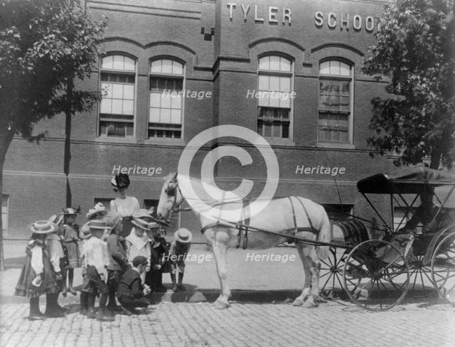 Children studying a horse and buggy outside the Tyler School, Washington, D.C., (1899?). Creator: Frances Benjamin Johnston.