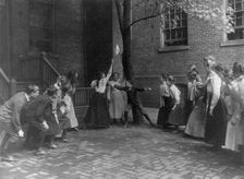 Children playing game with handkerchief on stick in school yard, Washington, D.C., (1899?). Creator: Frances Benjamin Johnston