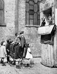 Children watching a Punch and Judy show in a London street, 1936. Artist: Donald McLeish