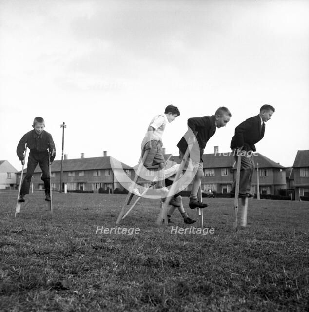 Children walking on stilts, c1955. Creator: Arthur Charles Kirby Ware.