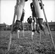 Children walking on stilts, c1955. Creator: Arthur Charles Kirby Ware