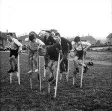 Children walking on stilts, c1955. Creator: Arthur Charles Kirby Ware