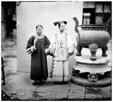 China: a Manchu woman with her maid standing beside a bronze burner, Beijing, 1869. Creator: John Thomson