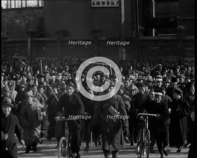 Chinese Refugees Including Several With Bicycles Spilling Through Barriers..., 1937. Creator: British Pathe Ltd.