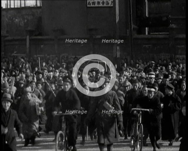 Chinese Refugees Including Several With Bicycles Spilling Through Barriers..., 1937. Creator: British Pathe Ltd.
