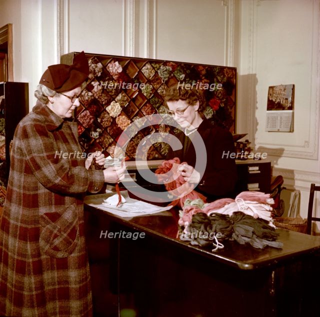 Choosing wools at the shop counter, Royal School of Needlework, c1955. Creator: Arthur Charles Kirby Ware.