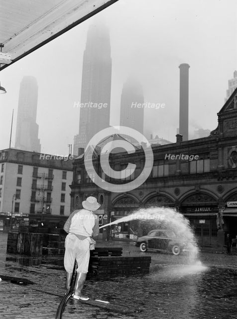 City sanitation workman washing streets at Fulton fish market, New York, 1943. Creator: Gordon Parks.