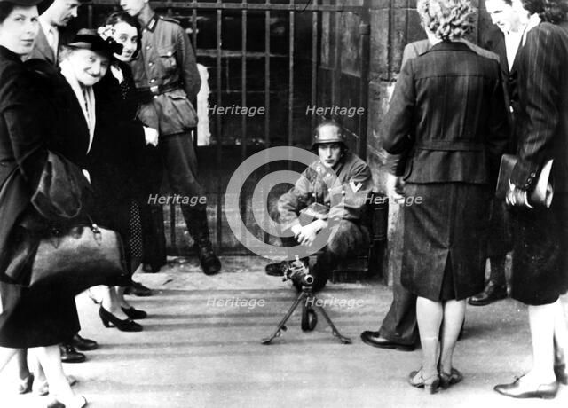 Civilians in front of a German guard post with a machine gun, Paris, June 1940. Artist: Unknown