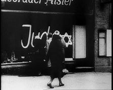 Civilians Looking at Shop Window with Graffiti Reading: Juden on it, 1933. Creator: British Pathe Ltd