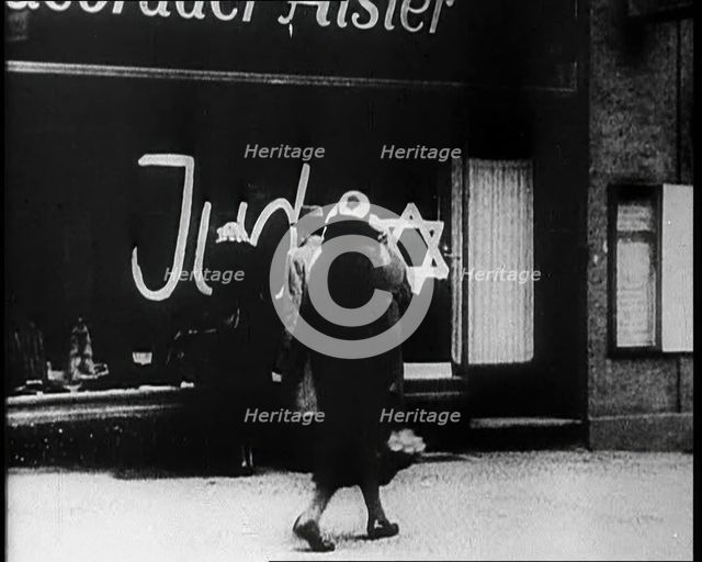 Civilians Looking at  Shop Window with Graffiti Reading: ‘Juden’ on it, 1933. Creator: British Pathe Ltd.