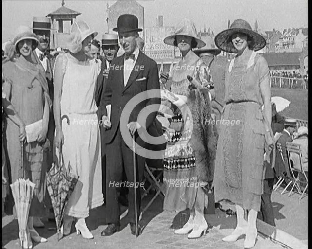 Civilians Wearing Smart Outfits and Hats Posing for the Camera During a Horse Race, 1920. Creator: British Pathe Ltd.