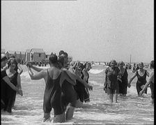 Civilians Wearing Swimsuits Enjoying a Sunny Day Dancing at a Very Crowded Beach, 1920. Creator: British Pathe Ltd