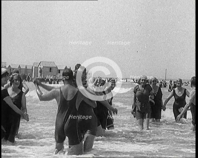 Civilians Wearing Swimsuits Enjoying a Sunny Day Dancing at a Very Crowded Beach, 1920. Creator: British Pathe Ltd.