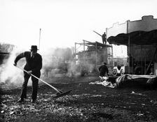 Cleaning up at Hampstead Funfair, April 1952. Creator: Henry Grant
