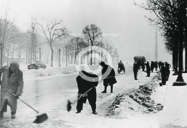 Clearing snow on the Champs Elysees, German-occupied Paris, winter, 1941. Artist: Unknown