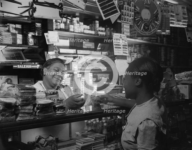Clerk waiting on a customer in the store owned by Mr. J. Benjamin, Washington, D.C., 1942. Creator: Gordon Parks.