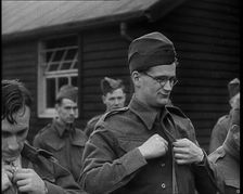 Close up on a Male British Soldier Wearing a Side Cap and Round-Rimmed Glasses Buttoning up..., 1939 Creator: British Pathe Ltd