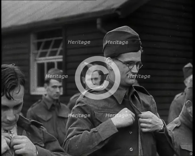 Close up on a Male British Soldier Wearing a Side Cap and Round-Rimmed Glasses Buttoning up..., 1939 Creator: British Pathe Ltd.