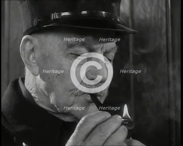 Close up on Male British Chelsea Pensioner as He is Lighting a Pipe, 1939. Creator: British Pathe Ltd.