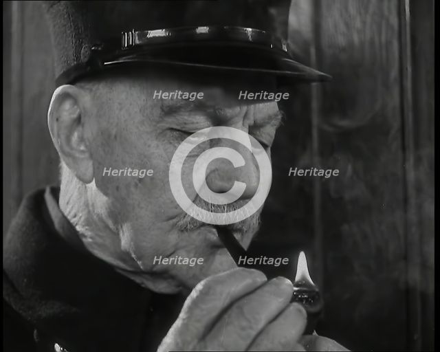 Close up on Male British Chelsea Pensioner as He is Lighting a Pipe, 1939. Creator: British Pathe Ltd.