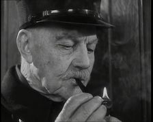 Close up on Male British Chelsea Pensioner as He is Lighting a Pipe, 1939. Creator: British Pathe Ltd