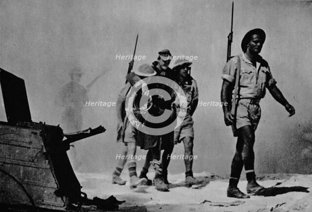 'Close-up of a great battle. The Australians are bringing in a wounded prisoner', 1942 (1944). Artist: Unknown.