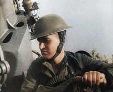 Close up of a Male British Soldier Wearing a Steel Helmet and Sitting Next to an Anti-Air..., 1939. Creator: British Pathe Ltd