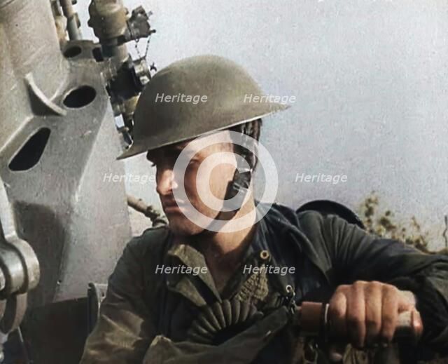 Close up of a Male British Soldier Wearing a Steel Helmet and Sitting Next to an Anti-Air..., 1939. Creator: British Pathe Ltd.