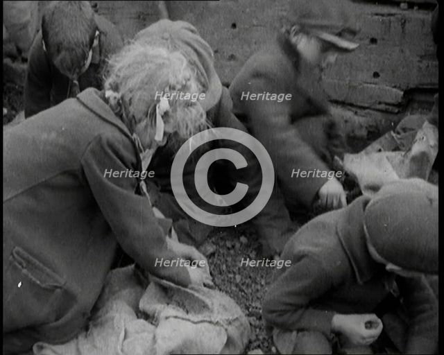 Close up of Male and Female Children Picking Through Small Heaps of Coal on the Ground, 1924. Creator: British Pathe Ltd.
