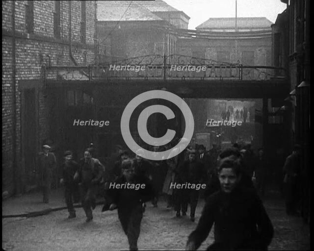 Crowd of Men Walking Through the Street Towards the Camera, 1933. Creator: British Pathe Ltd.