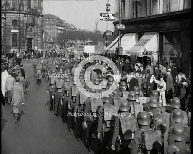 Crowd Watching German Soldiers Marching Down a Street Away from the Camera, 1930s. Creator: British Pathe Ltd.