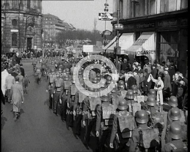 Crowd Watching German Soldiers Marching Down a Street Away from the Camera, 1930s. Creator: British Pathe Ltd.