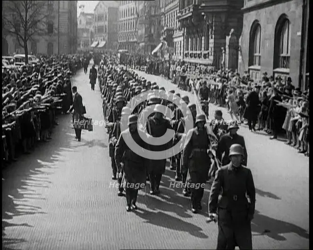 Crowd Watching German Soldiers Marching Down a Street Towards the Camera, 1930s. Creator: British Pathe Ltd.