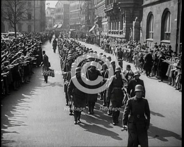 Crowd Watching German Soldiers Marching Down a Street Towards the Camera, 1930s. Creator: British Pathe Ltd.