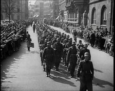 Crowd Watching German Soldiers Marching Down a Street Towards the Camera, 1930s. Creator: British Pathe Ltd
